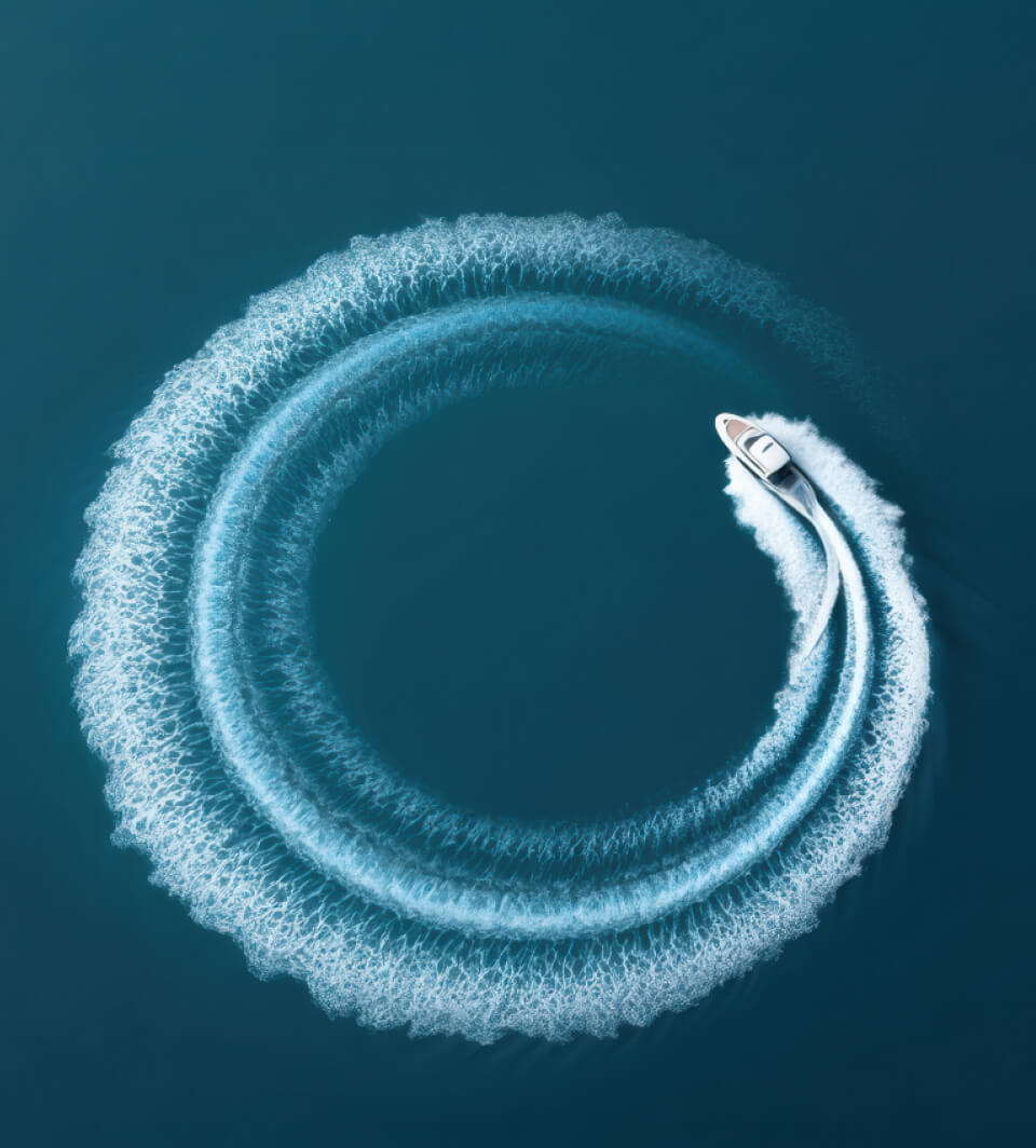 Speedboat circling in the ocean leaving a white spray trail