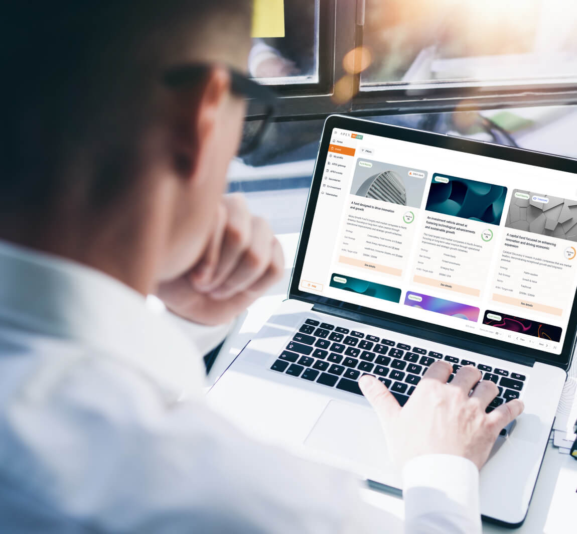 View over a mans shoulder using a laptop with his hand on the keyboard